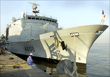 An port worker looks at the French naval ship Var in Mumbai Port
