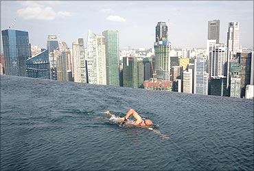 A guest swims in the infinity pool of the Skypark that tops the Marina Bay Sands hotel towers in Singapore.
