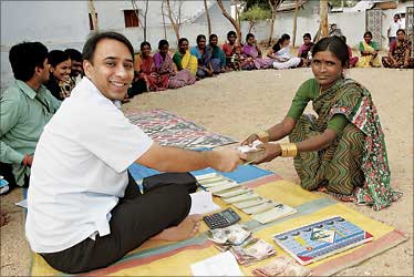 Akula giving money to a village woman.