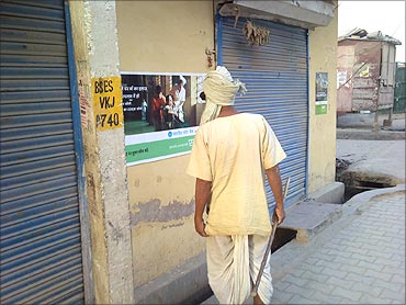 A rural customer examines a poster of Eko.
