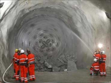 Miners stand in front as the drill machine 'Gaby' breaks through the rock at the section Erstfeld-Amsteg at the construction site of the Gotthard Base Tunnel on June 16, 2009.