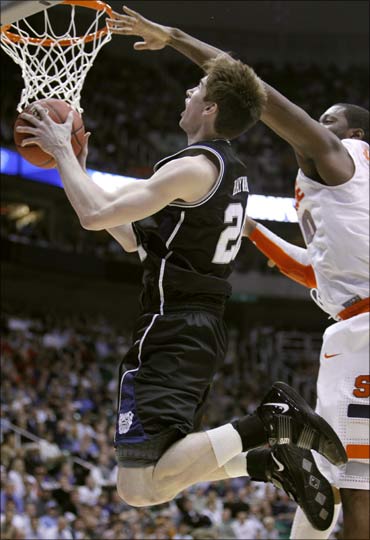 Gordon Hayward (L) goes up for a basket against Syracuse at a basketball game in Salt Lake City.