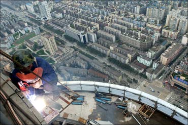 A Chinese welder works outside a building in downtown Chengdu.