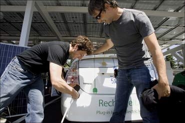 Google Inc. founders Sergey Brin  and Larry Page plug in an electric hybrid car at Google office.