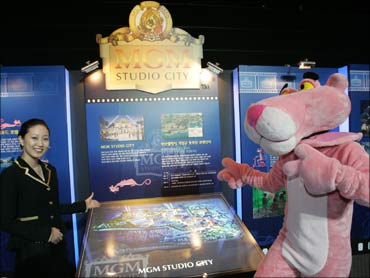A South Korean woman poses with Pink Panther in front of a MGM theme park billboard in Pusan, Seoul.