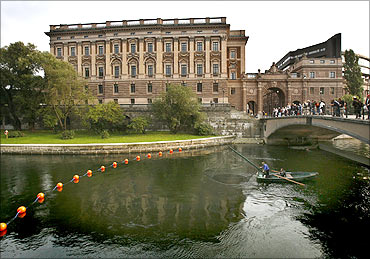 A fisherman lifts his net from a canal next to Sweden's Parliament Building, in Stockholm.