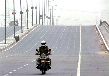 A policeman patrols a deserted national highway during a protest in New Delhi.