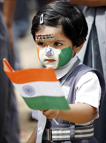 A schoolgirl, with her face painted in colours of the Indian national flag.