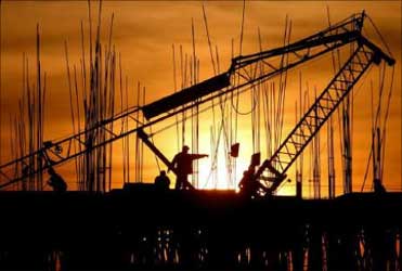Construction workers work at a site as the sun sets in Chandigarh.