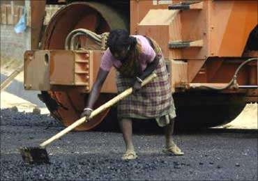 A woman works at a road construction site.