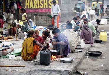 Homeless people prepare their food on roadside in Ahmedabad.