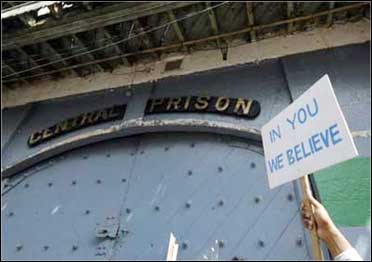 An employee of Satyam Computer Services holds aloft a placard outside the gate of Chanchalguda jail.