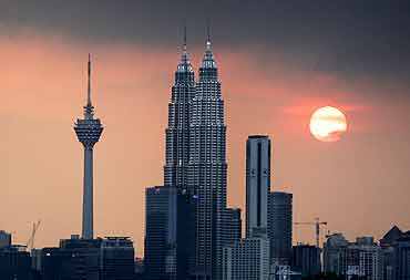 The sun sets near the Petronas Twin Towers.