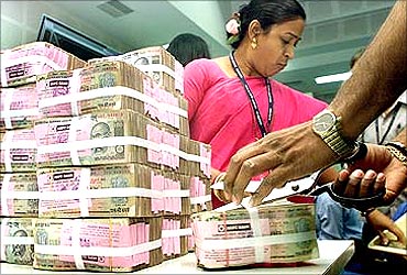 RBI employees with stacks of bank notes.