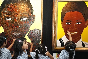 Students gather next to paintings of US President Barack Obama.