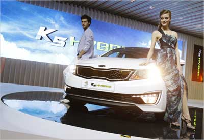 Models pose with Kia Motors' K5 Hybrid during a media preview of the Seoul Motor Show in Goyang.