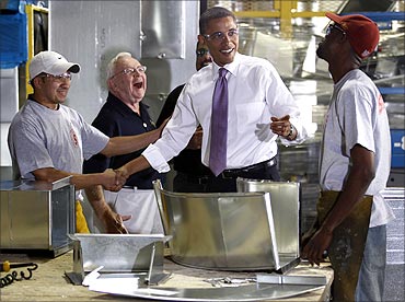 US President Barack Obama shares a laugh with workers during a tour of Stromberg Metal Works.