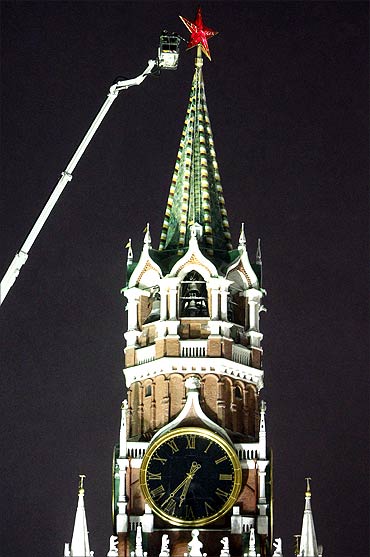 Workers remove snow from a star on the Spassky Tower of the Kremlin in central Moscow.