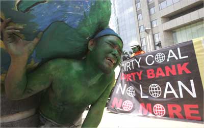 An environmental activist carries a globe during a protest near the World bank office in Jakarta.