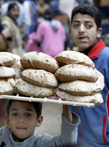 A child carries a tray of bread on his head in Cairo.