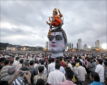Devotees watch idols of the Hindu elephant god Ganesh, the deity of prosperity and Lord Shiva during
