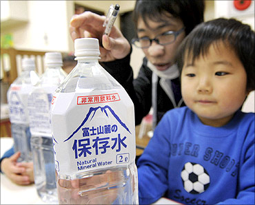 A child holds a bottle of emergency long shelf-life mineral water at a nursery school in Tokyo.