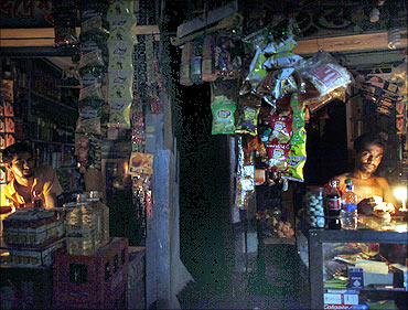 Vendors work in roadside shops during a power cut in an old part of Dhaka.