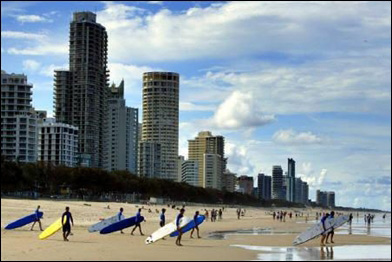 Longboard surfers walk into the water at the Main Beach at Surfer's Paradise.