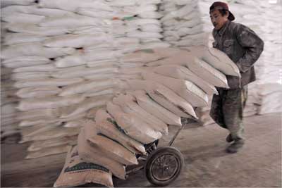 A worker unloads bags of flour at a foodstuff wholesale market in Shenyang, China.