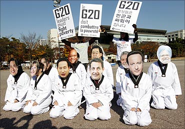 Oxfam protesters wearing masks of G20 leaders urging them to fight poverty in Seoul.