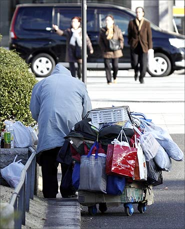 A homeless man packs up his belongings on a street in Tokyo.