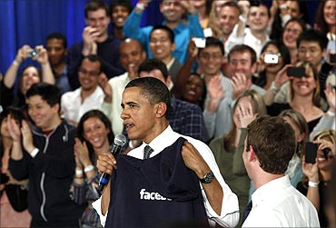 Obama is presented with a hooded sweatshirt from Facebook CEO Mark Zuckerberg.