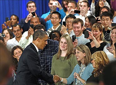 Obama greets attendees as he arrives for a town hall meeting at Facebook headquarters.
