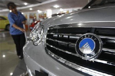 A worker cleans the floor at a showroom in the headquarters of Zhejiang Geely Holding Group in Hangzhou, Zhejiang