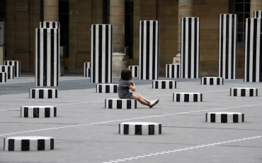 A child sits on a column of 'Les Deux Plateaux' work in Paris.