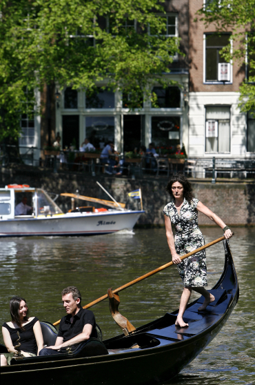 A woman rows her gondola in Amsterdam.