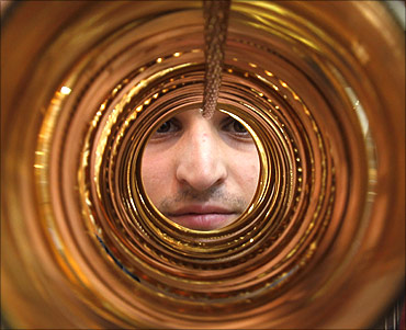 A goldsmith poses with gold bangles in his jewellery shop.