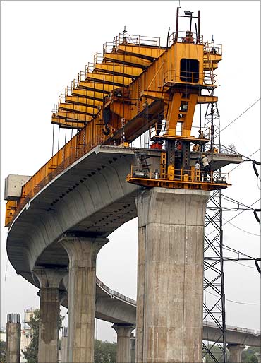 Delhi Metro Rail Corporation (DMRC) employees work at the construction of a flyover in New Delhi.