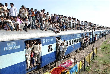 Hindu devotees travel on a crowded passenger train.