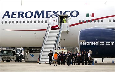 Crew members take photographs near an Aeromexico Boeing 777.