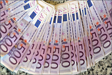 Euro notes are spread out at a bank branch in Madrid.