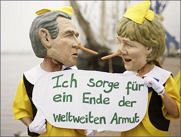 Activists from Oxfam dressed as German Chancellor Angela Merkel and former President George W Bush.