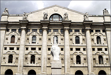 A sculpture called 'crippled hand is seen in front of the stock exchange palace in Milan.