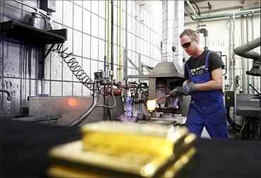 A worker casts a gold bar of melted gold granules at the Austrian Gold and Silver Separating Plant .