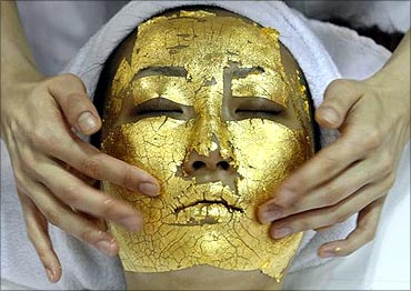 A model demonstrates the use of Umo Inc.'s 24-carat gold leaf, Gold Facial Treatment.
