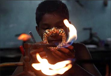 A goldsmith works on a gold bangle at a workshop in Kolkata.