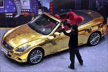 A man films a gold-plated Infiniti G37 at a jewelry store in Nanjing.