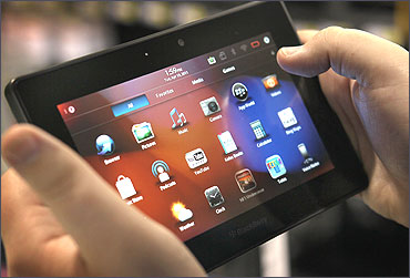 An employee demonstrates a Blackberry Playbook tablet at a Best Buy store.