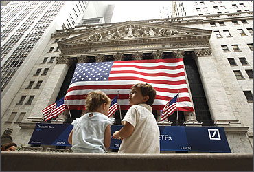 Two children sit on a bench outside the New York Stock Exchange.