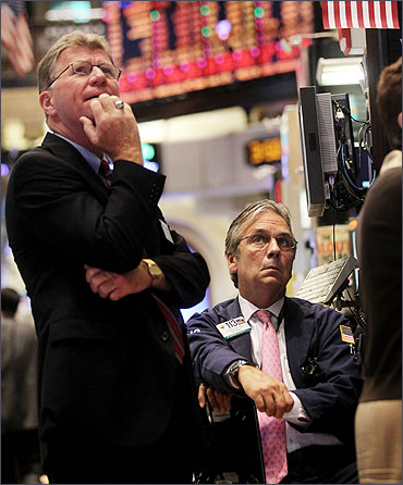Traders watch a stock ticker on the floor of the New York Stock Exchange.